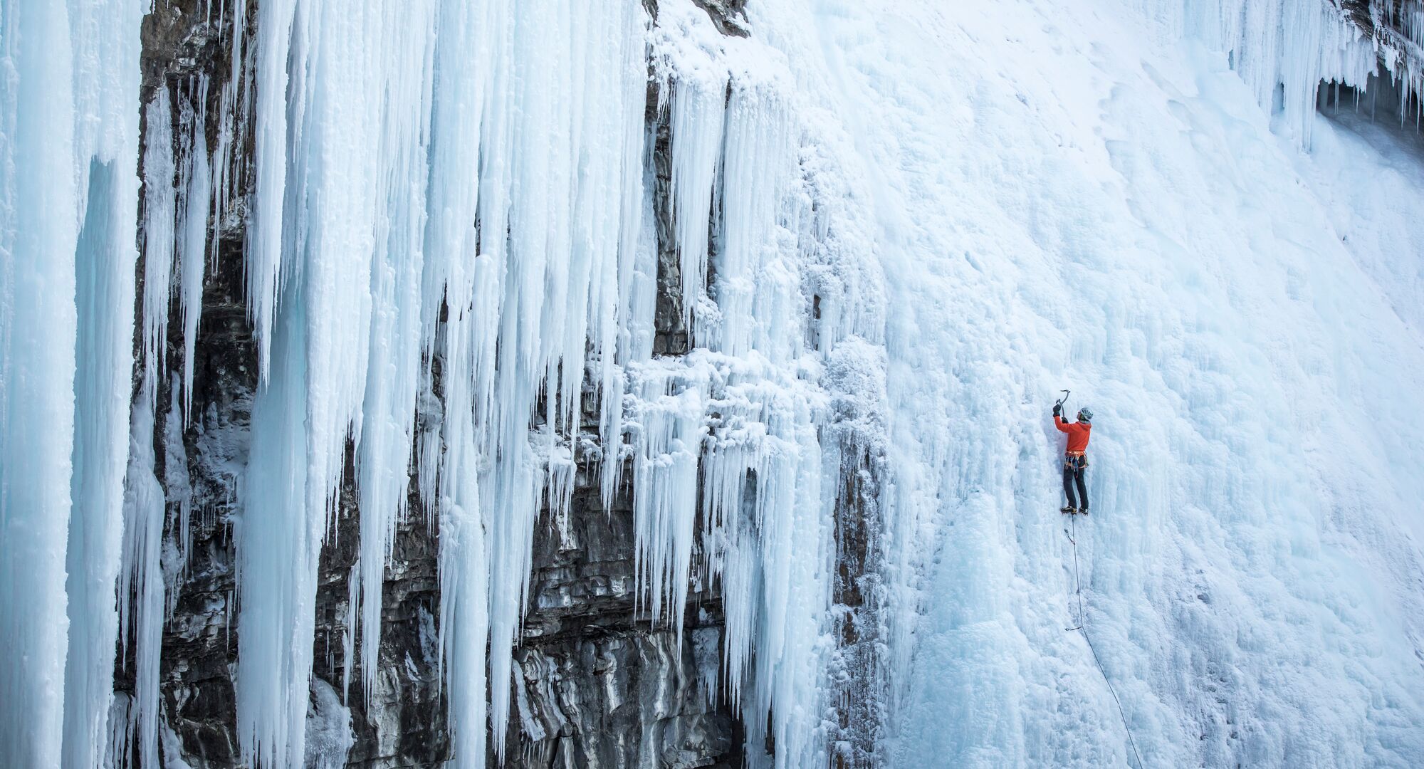 Person ice climbing on the frozen falls of Johnston Canyon